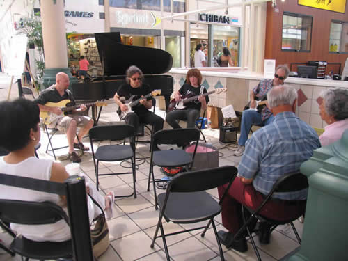 Photo images of Long Beach School of Music students and teachers performing at the Lakewood Center Mall to raise money for the Piano Fund of the Long Beach Branch of the Music Teachers' Association of California.